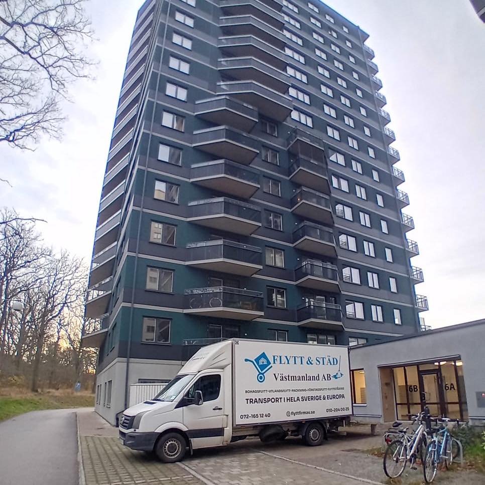 Flyttbil utanför ett högt hus i Västerås